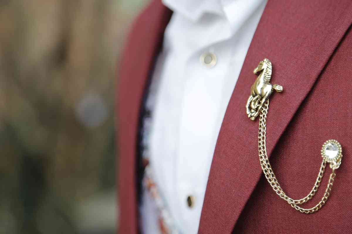 赤い乗馬ジャケットに馬形のブローチ